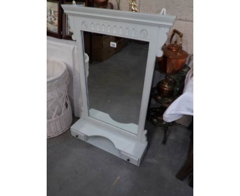 A shabby chic bedroom mirror with shelf