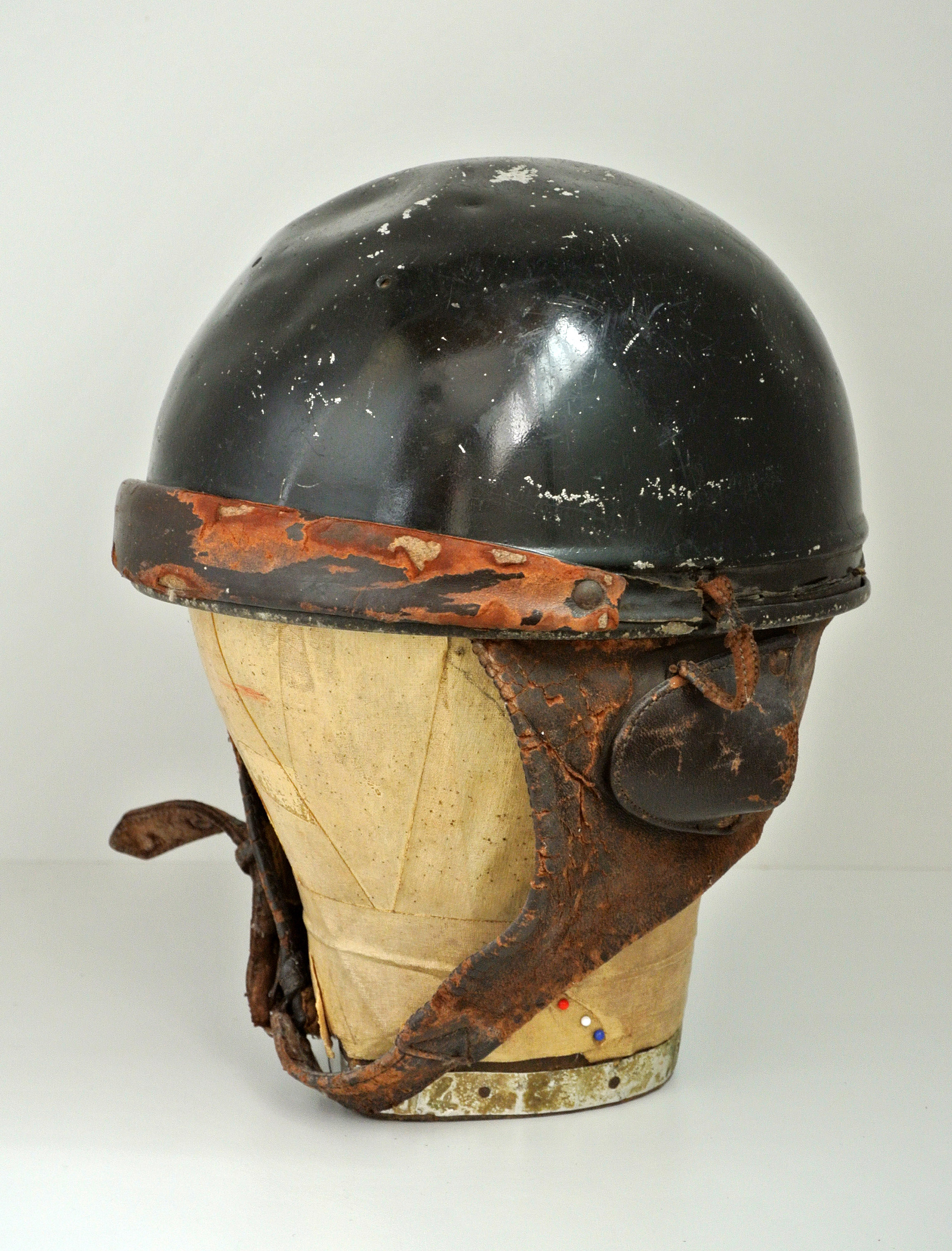 AN EARLY 20TH CENTURY MOTORCYCLE HELMET With leather chin strap and