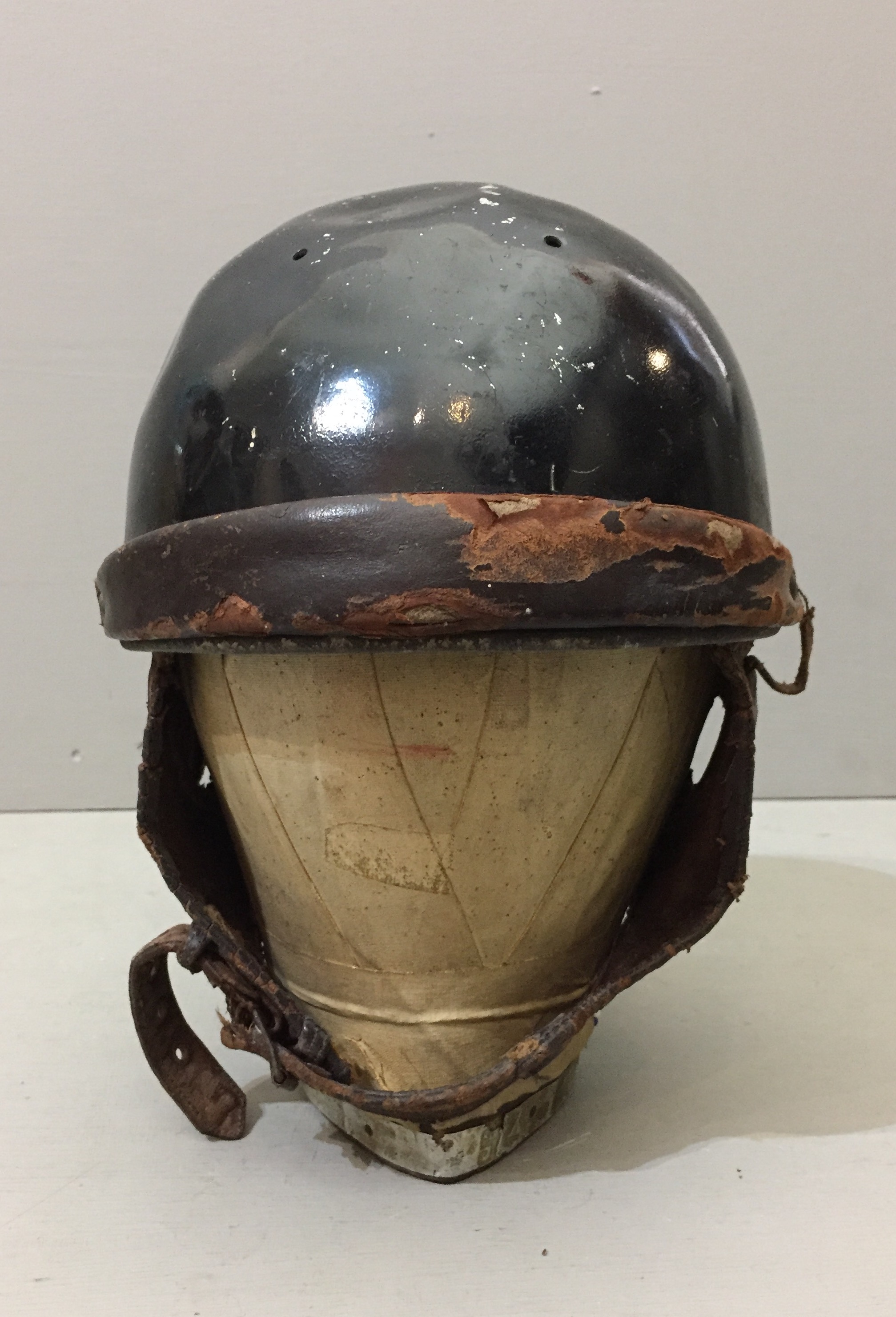 AN EARLY 20TH CENTURY MOTORCYCLE HELMET With leather chin strap and