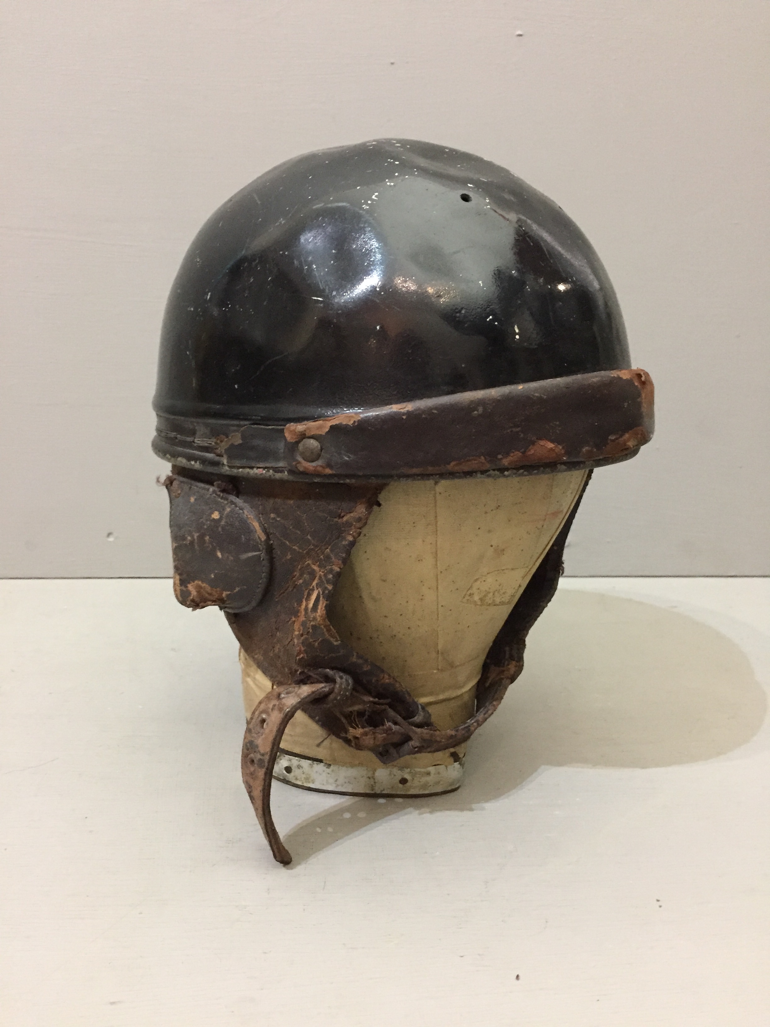 AN EARLY 20TH CENTURY MOTORCYCLE HELMET With leather chin strap and