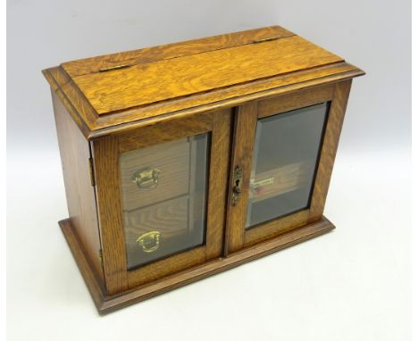 Edwardian oak smokers cabinet, the glazed doors enclosing three fitted drawers, pipe rack and shelves, W42cm x H31cm x D22cm 