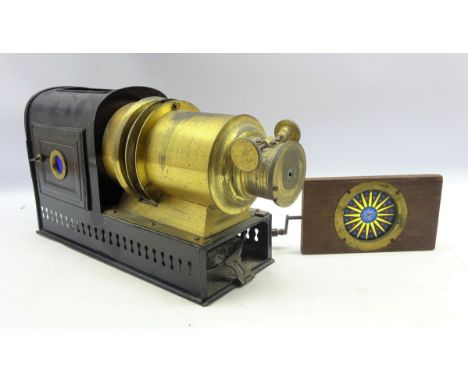 Late 19th Century black japanned metal and brass magic lantern with a mahogany mounted Rackwork Chromatrope magic lantern sli