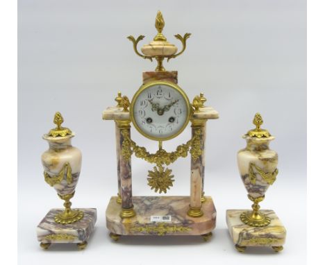 Early 20th century gilt metal and pink marble portico clock garniture, urn shaped pediment above circular Arabic dial, floral