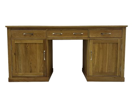 Contemporary light oak twin pedestal desk, fitted with three drawers over two cupboards with chrome handles, the central draw