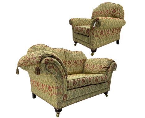 Traditional design two seat sofa, high back with scrolled arms, upholstered in beige fabric with red and green damask motifs,