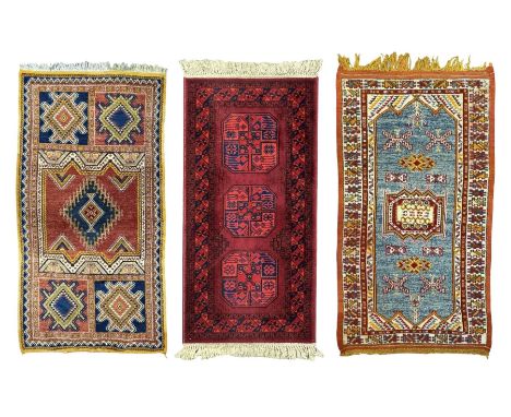 Persian Qashqai crimson ground rug, the field with central indigo and yellow medallion with geometric motifs, flanked by smal