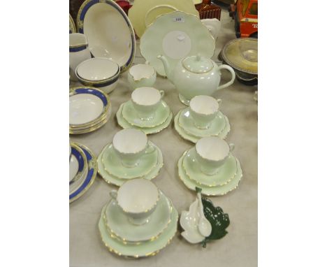 A Staffordshire part-tea service, apple green ground, gilt-edged rim; a Carltonware pickle tray and spoon