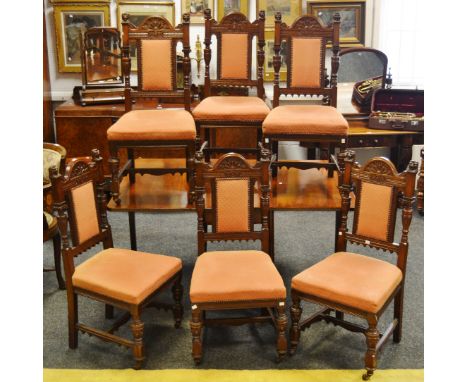 A set of six Aesthetic movement oak dining chairs, arched top rail with blind fretworked sunrise, padded back flanked by turn