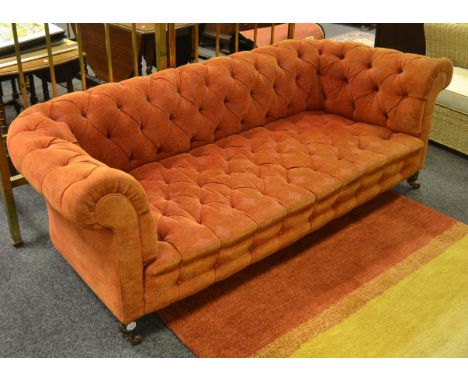 An early 20th century Chesterfield sofa, upholstered in terracotta coloured fabric