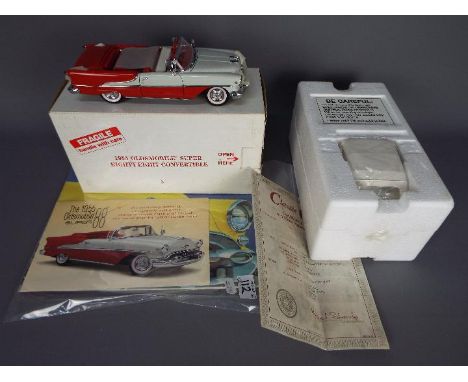 Danbury Mint - A boxed Danbury Mint 1:24 scale 1955 Oldsmobile Super Eighty-Eight Convertible. The model in red and white app