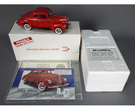 Danbury Mint - A boxed Danbury Mint 1:24 scale 1940 Ford Deluxe Coupe. The model in red appears to be in Mint condition house