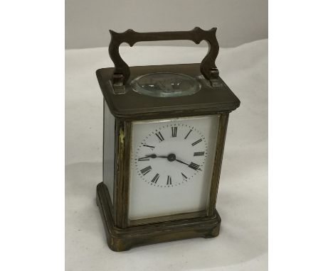 A BRASS AND GLASS CARRIAGE CLOCK, THE GLASS BEING BEVELLED SHOWING ALL FOUR SIDES OF THE CLOCK'S INNER WORKINGS, WITH BRASS H