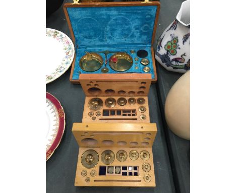 A SET OF BRASS TRAVELLING SCALES AND TWO SETS OF BRASS WEIGHTS ALL IN WOODEN BOXES 