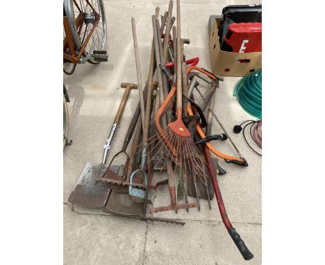 A LARGE ASSORTMENT OF VINTAGE GARDEN TOOLS TO INCLUDE SPADES, RAKES AND BOW SAWS ETC 