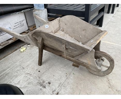 A SMALL WOODEN WHEEL BARROW PLANTER 