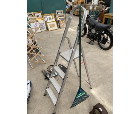 A THREE RUNG ALUMINIUM STEP LADDER AND A LEAF RAKE 