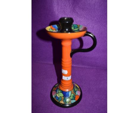 A large Bursley ware candlestick holder having vibrant orange ground and tube lined design accented with a variety of colours