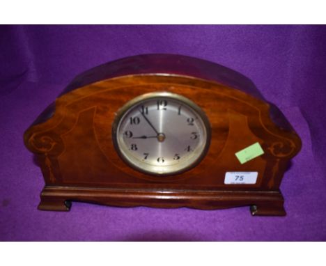 A wood cased mantle clock having inlaid detail.