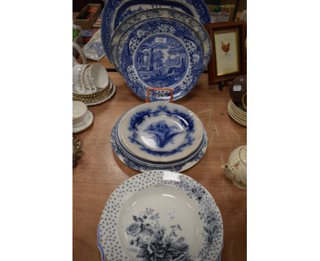 A variety of vintage and antique blue and white ware including platters and plates.