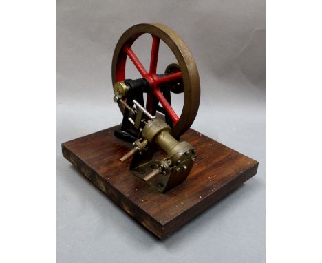 A metal stationary engine raised on a square shaped wooden plinth, measuring 19cm high