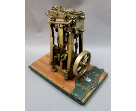 A brass vertical stationary engine, mounted on a mahogany and painted rectangular plinth, measuring 27cm tall, together with 