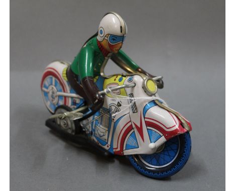 A Chinese tin plate and clockwork motorcycle and rider (MS-702), the rider having white helmet, green jacket &amp; brown trou