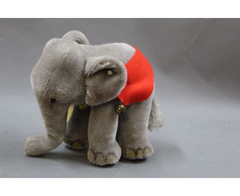 A 1950/60's Steiff standing elephant, having mohair body, with button and neck tag, measuring 22cm high, VGC