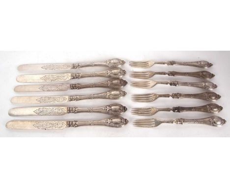 Six pairs of Victorian silver dessert eaters having decorative loaded handles, engraved with an eagle, the blades part chased