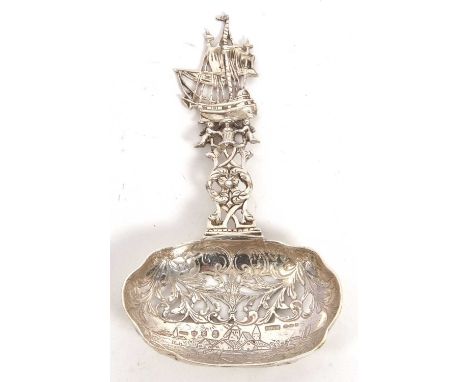A Dutch cast silver sifting spoon having a scallop shaped bowl, chased, pierced and engraved with windmills, scrolls and foli