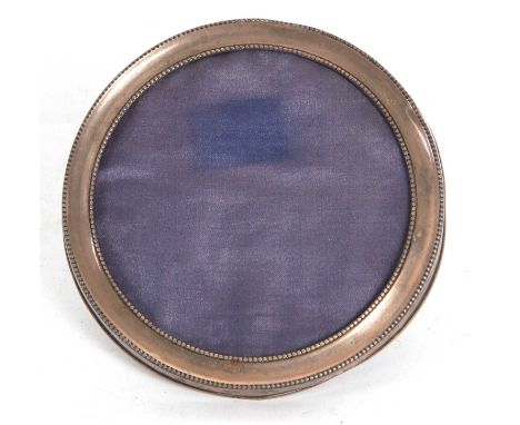 An early 20th Century silver photograph frame of circular form having beaded edge detail, easel backed, hallmarked for Birmin