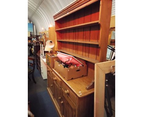 An early 20thC pine dresser, the three shelf rack over a cupboard and drawer base