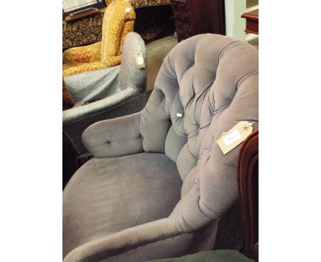 A blue upholstered button-back armchair 