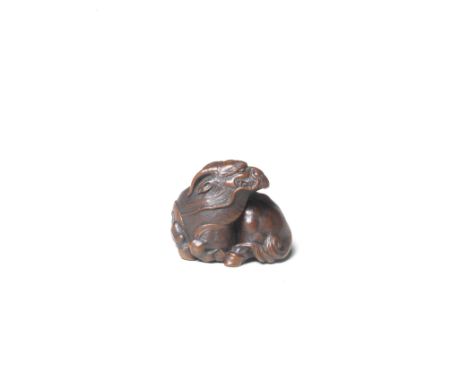 A fine wood netsuke of a recumbent kirinBy Ikkan (1817-1893), Nagoya, 19th centuryLying with its head slightly raised and tur