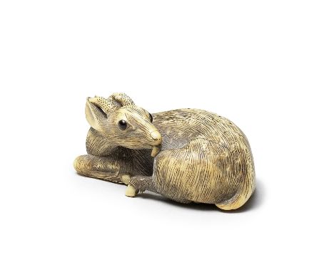 An ivory netsuke of a recumbent deerBy Garaku, Osaka, Edo period (1615-1868), early 19th centurySeated, its legs drawn into a