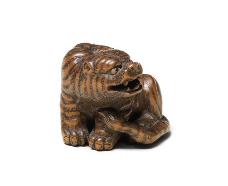 A wood netsuke of a tigerBy Masanao, Yamada, Ise Province, Edo period (1615-1868), 19th centuryThe tiger seated, turning to i