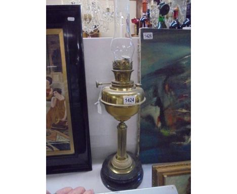 A brass oil lamp with reeded column on a ceramic base, COLLECT ONLY.