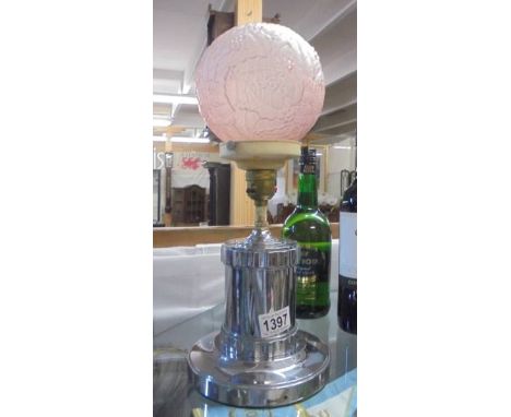 An Art deco chrome table lamp with holly decorated pink glass shade.