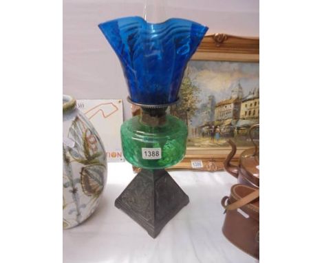 An early 20th century oil lamp on cast iron base with green glass font and blue glass shade. COLLECT ONLY.Shade has a couple 