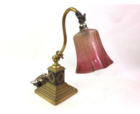 BRASS TABLE LAMP, EARLY 20TH CENTURY etched cranberry glass shade, adjustable whiplash support, square column decorated in re
