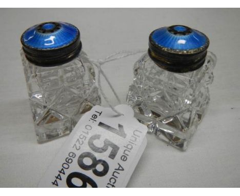 Two small glass salt pot with silver and enamel tops.