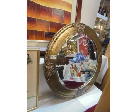 An art deco circular brass framed bevel edged mirror, 60 cm diameter. COLLECT ONLY.