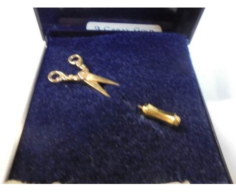 A 9ct gold tie pin in the shape of a pair of scissors.