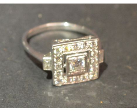 An 18ct. White Gold Diamond Ring of Square Form with a central diamond surrounded by diamonds within a pierced setting, appro