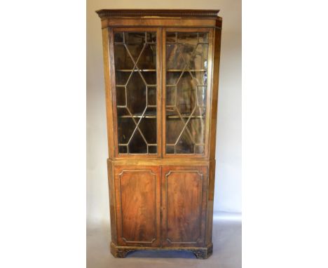 A 19th Century Mahogany Standing Corner Cabinet with a moulded cornice above two astragal glazed doors enclosing shelves, the