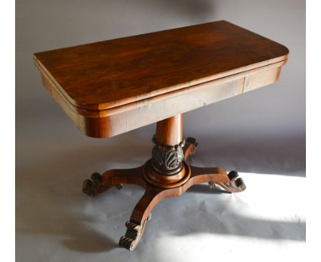 A William IV Rosewood Card Table, the hinged top above a plain frieze raised upon a tulip carved tapering column with quadrip