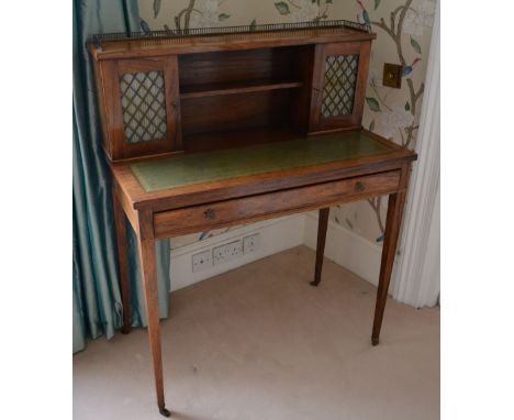 A William IV Rosewood Bonheur du Jour with a brass galleried top above a central shelf flanked by brass grilled and fabric do