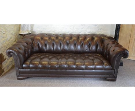 A Brown Leather Upholstered Three Seater Chesterfield Sofa with a Button Upholstered Back and Seat with scroll arms, 218 cms 