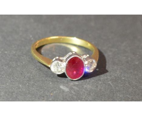 An 18ct. Yellow Gold Ruby and Diamond Three Stone Ring, with a central oval ruby flanked by diamonds, approximately 0.40 / 0.