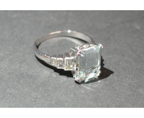 An 18ct. White Gold Aquamarine and Diamond Ring, set with a rectangular aquamarine and with baguette diamond shoulders, appro