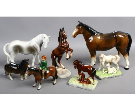 A group of seven ceramic models of horses, two with foals one with a rider.